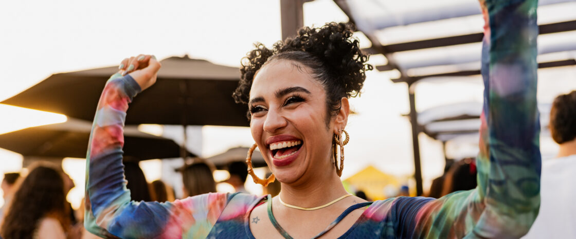 Young woman dancing at a party outdoors.