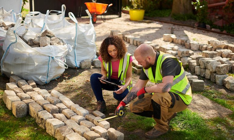 Two landscapers building a stone wall