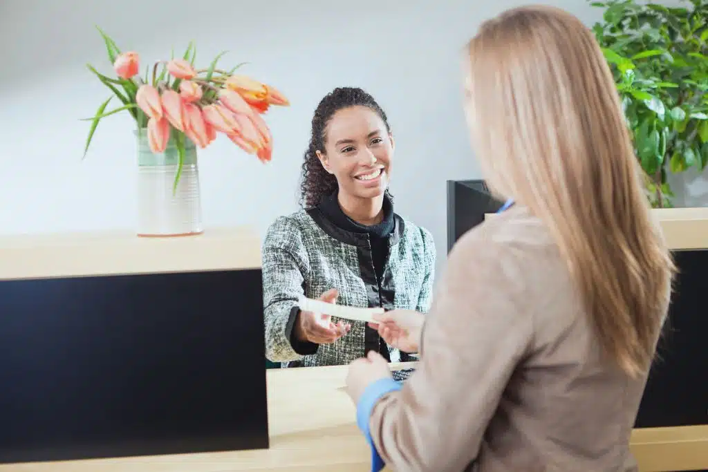 Woman working with a bank teller to set up automatic savings transfers