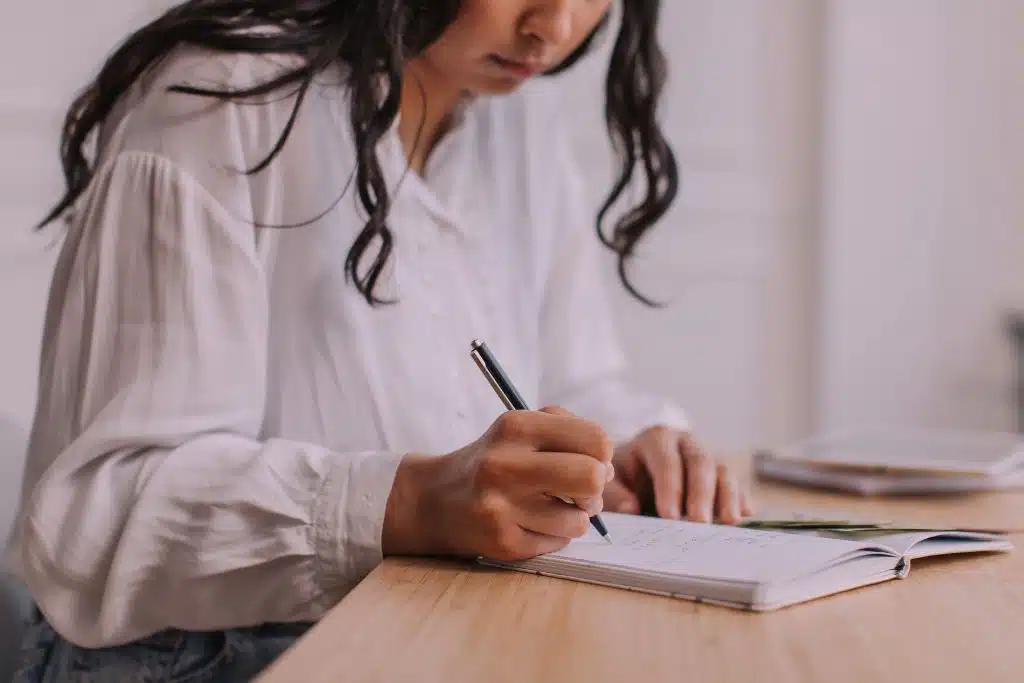 Woman writing down her options to cut expenses and still enjoy life