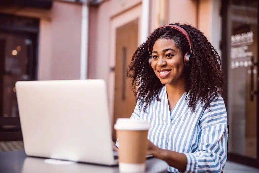 Smiling woman on laptop reviewing a credit report and smiling