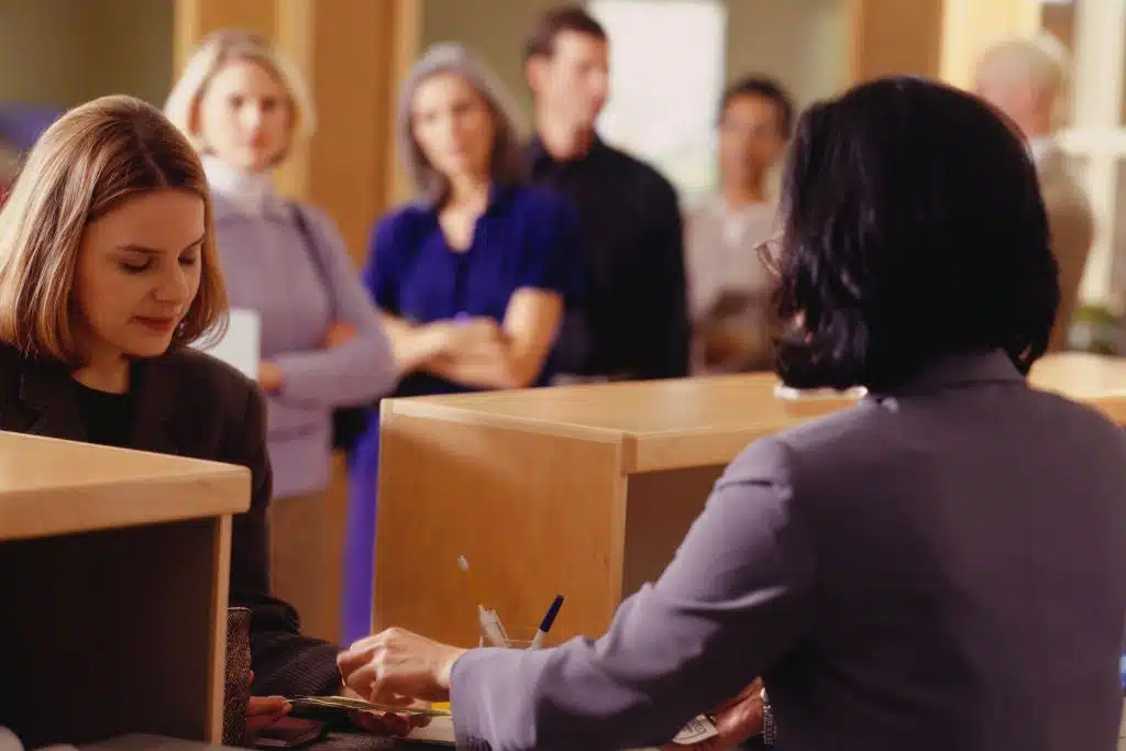 Smiling person opening a new bank account with a banker