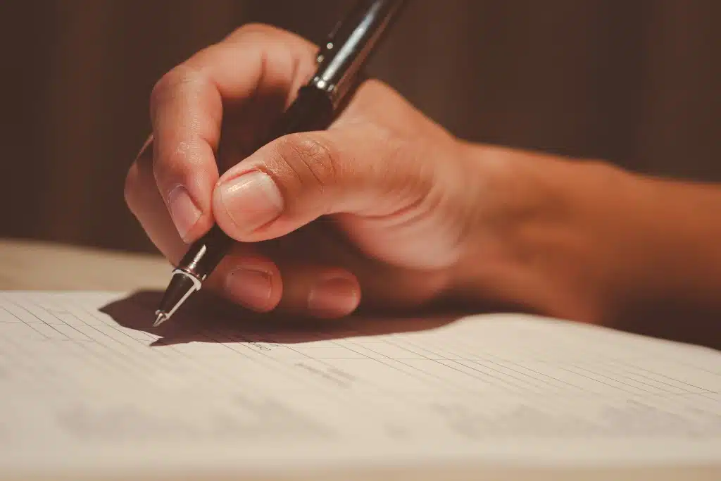 Person organizing paperwork to file an insurance claim online