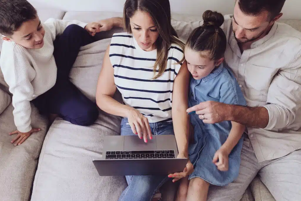 Family with young children saving for college around a piggy bank
